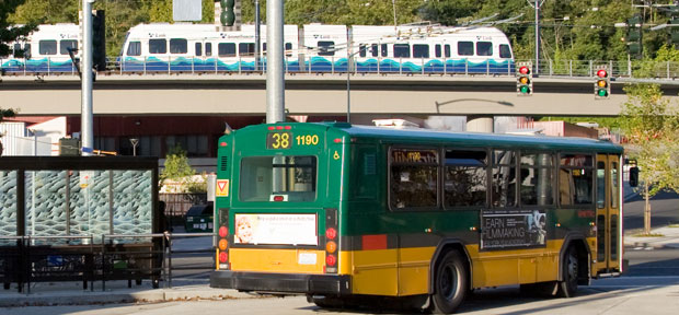 Photo of a bus and a train arriving at a station.