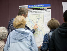 A group of people reviewing a bus route map.